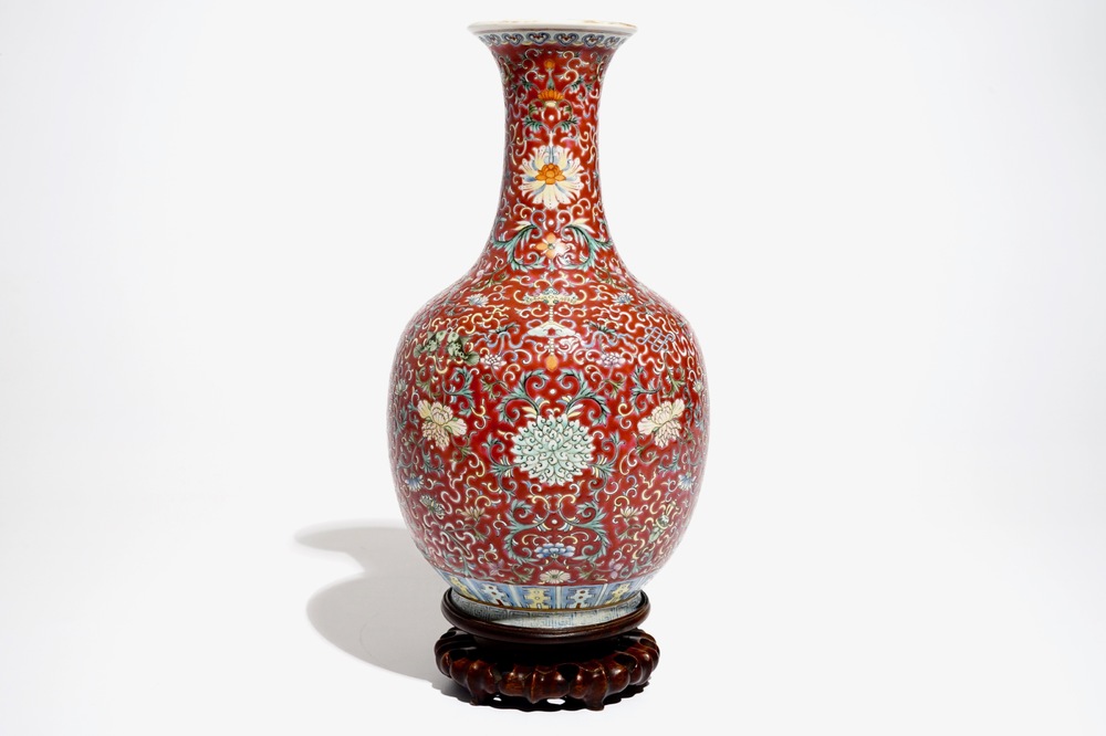 A Chinese red-ground famille rose bottle vase, Qianlong mark, 19/20th C.